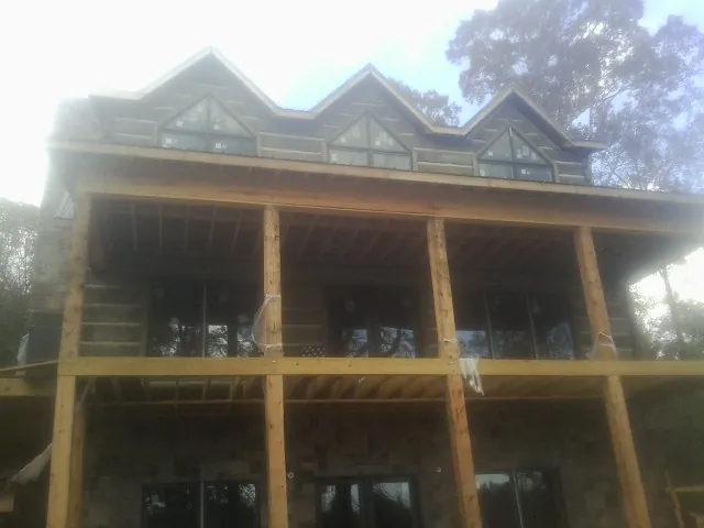 Dormers and porch framing on a large log home under construction — Roof Coating work by our crew in Paint Bank