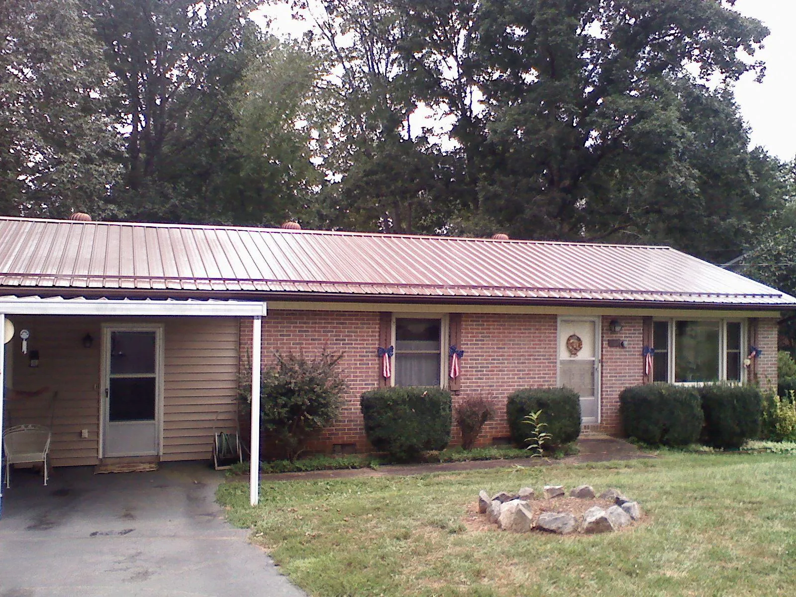 Bronze metal roof and carport on a brick ranch home — Roof Repair work by our crew in Paint Bank